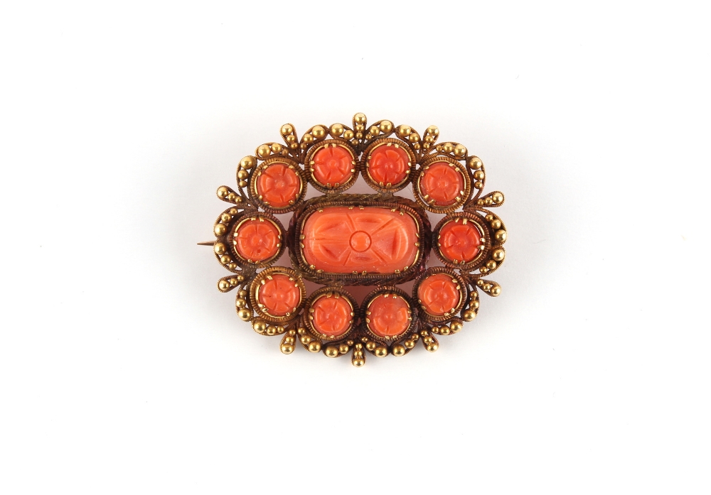 A late 19th / early 20th century unmarked gold (tested) carved coral oval brooch, 34mm wide (
