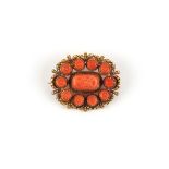 A late 19th / early 20th century unmarked gold (tested) carved coral oval brooch, 34mm wide (