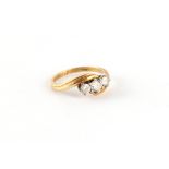 Property of a gentleman - an 18ct yellow gold diamond three stone crossover ring, the estimated
