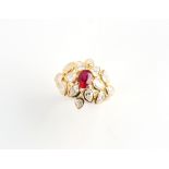 An 18ct yellow gold ruby & diamond floral cluster ring, the oval cushion cut ruby weighing