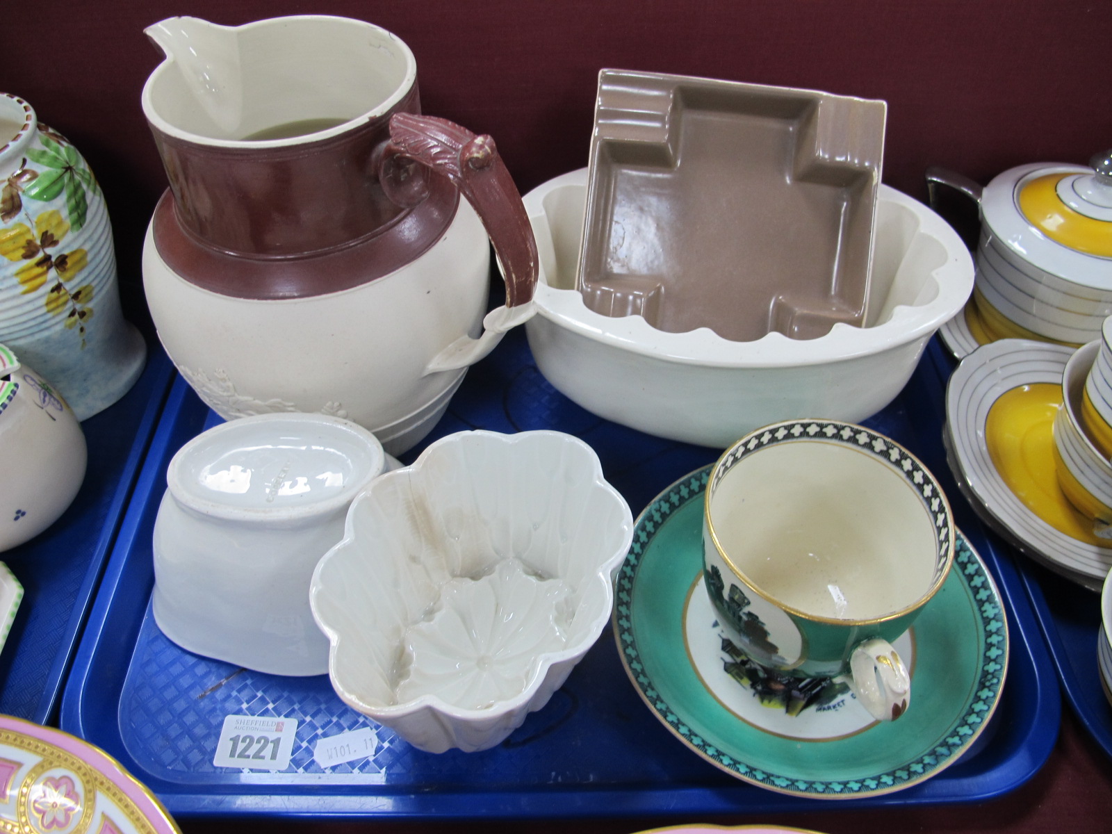 Three Jelly Moulds, a XIX Century jug, Poole ashtray, Welsh costume cup and saucer:- One Tray.