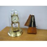 A XX Century Brass Anniversary Clock Under a Glass Dome, together with a XX Century Metronome in a