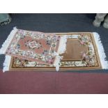 A Chinese Wool Tassled Rug, with floral decoration on brown ground 154 x 77cm. a similar smaller