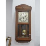 A 1940's Oak Cased Wall Clock, with a silvered dial, Arabic numbers, glazed door.