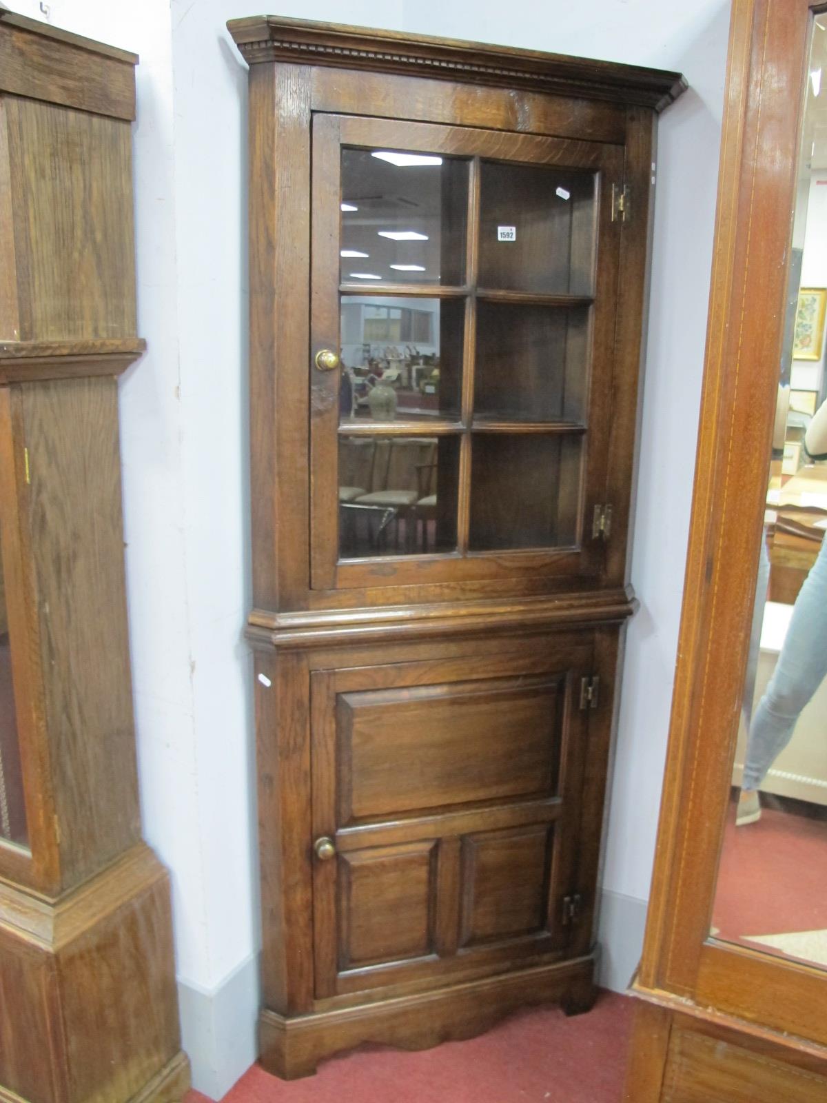 An Oak Flat Fronted Double Corner Cupboard with a glazed top two internal shelves over a panelled