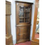 An Oak Flat Fronted Double Corner Cupboard with a glazed top two internal shelves over a panelled