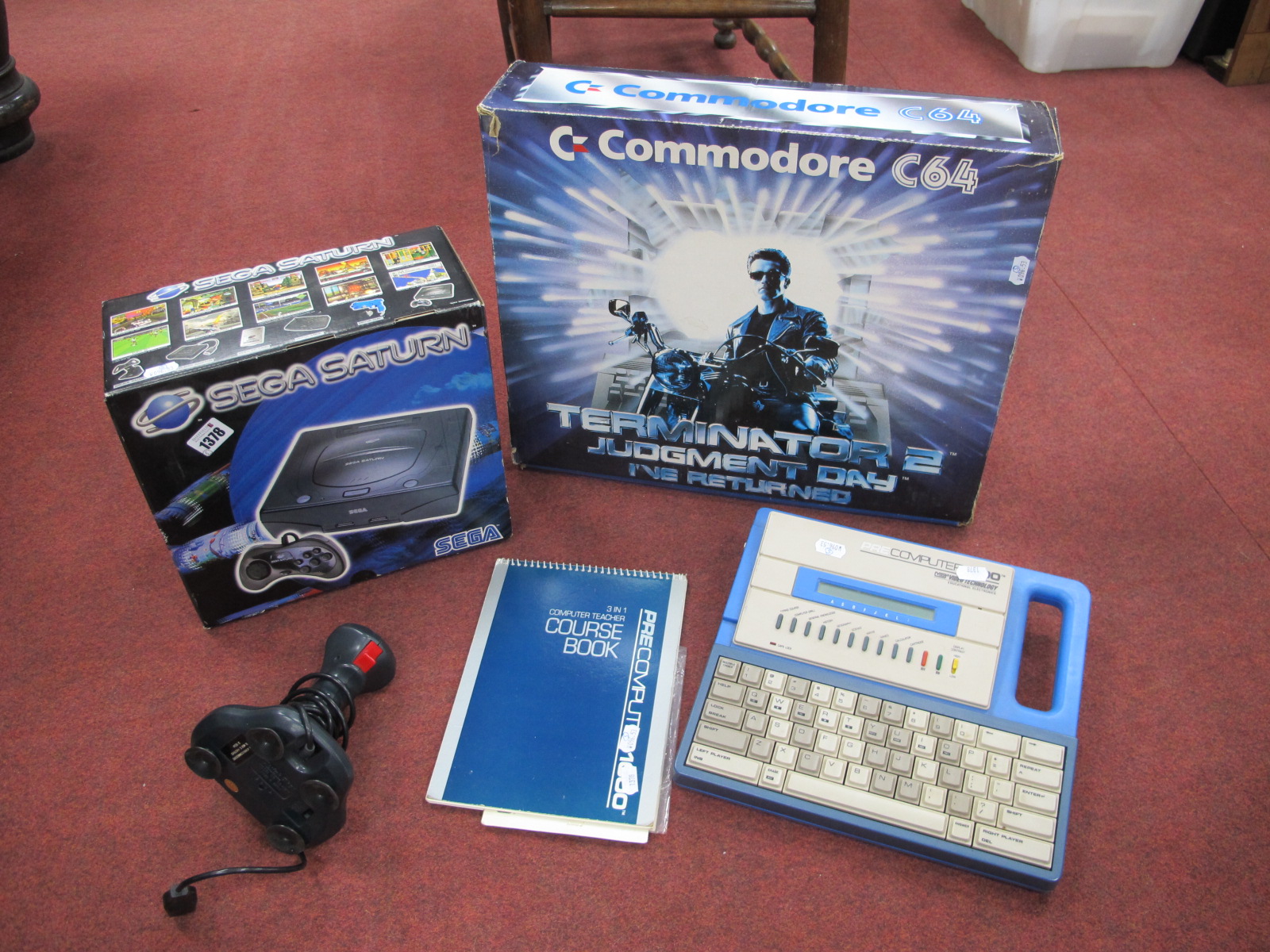 Vintage Computing Commodore 64, Sega Saturn, and pre computer 1000, along with associated joystick.