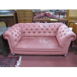 An Early XX Century Drop Arm Two Seater Chesterfield Settee, upholstered in pink dralon, 158cm wide.
