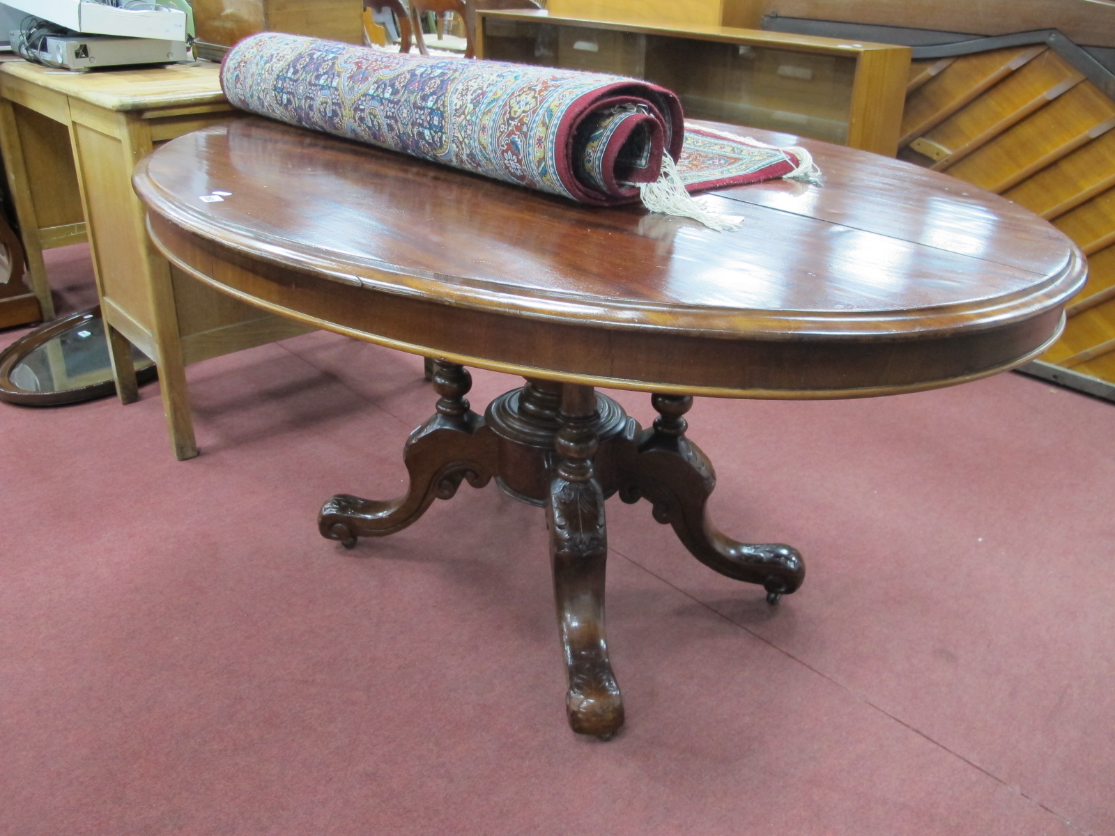 A XIX Century Centre Table, with oval mahogany tilt top, on carved four legged base, with turned