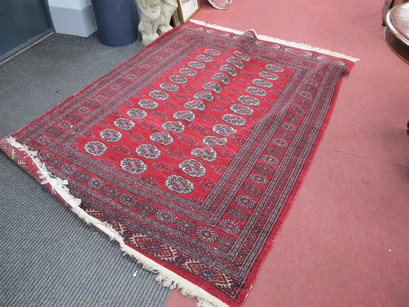 A Middle Eastern Wool Tassled Rug, with three bands of twelve central medallions, allover