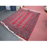 A Middle Eastern Wool Tassled Rug, with three bands of twelve central medallions, allover