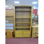 An Oak Bookcase, with four adjustable shelves, four small drawers, on square supports, 110cm wide