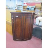 A Georgian Oak Cylinder Fronted Corner Wall Cupboard, with mahogany inlaid pediment and fixed