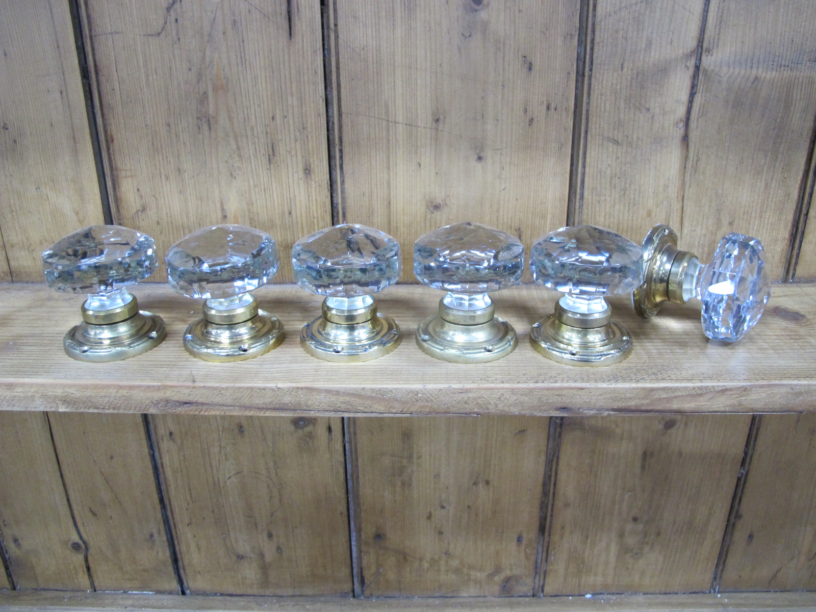 Six Matching Faceted Glass Door Knobs, circa early XX Century, on circular brass mounts, 6.5cm