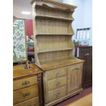 A XIX Century Pine Dresser, with stepped cornice, three shelves, shaped sides, base with a