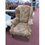 An XVIII Century Style Wing Chair, on cabriole legs, claw and ball feet, upholstered in cream floral