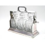 A Silver Plated Tantalus, with three cut glass decanters, (one damaged), 34cm long, 28cm high.