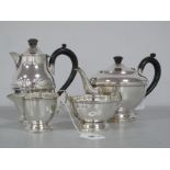 A Hallmarked Silver Four Piece Tea Service, of plain form, each with moulded central band, black
