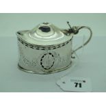 A Hallmarked Silver Mustard Pot, with hinged cover, of pierced oval form, engraved with swags of