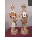 A Pair of Bisque Figurines, girl holding music satchel and boy holding similar bag, approximately