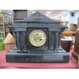 A XIX Century Black Slate Mantel Clock, with a circular dial, Arabic numerals, gilded brass centre