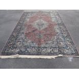 A Persian Style Wool Rug, pink border, with central motif, floral decoration, tassel ends, 300 x