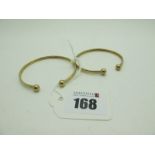 Two Modern Torque Style Child's Bangles, stamped "375" (5.5grams). (2)