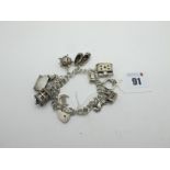 A Double Curb Link Charm Bracelet, to heart shape padlock style clasp, suspending assorted novelty