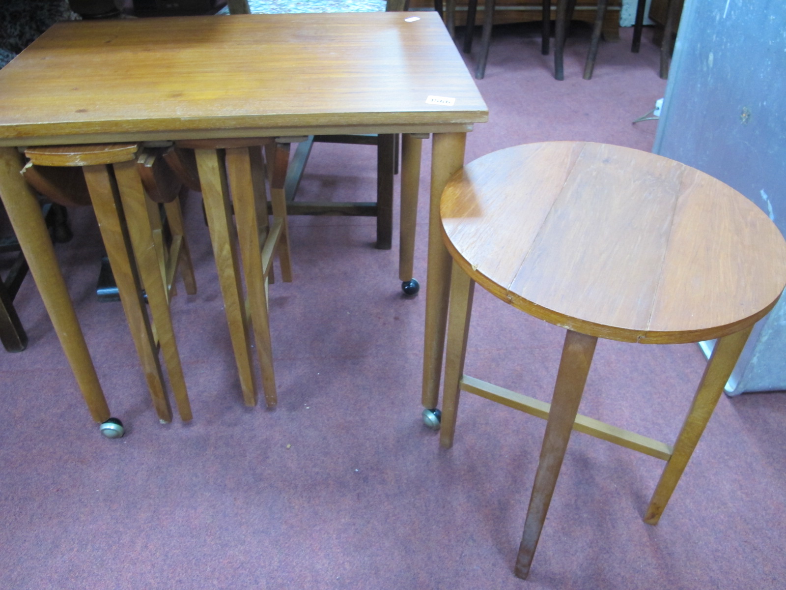 A Teak Wood Nest of Tables, with three folding tables.