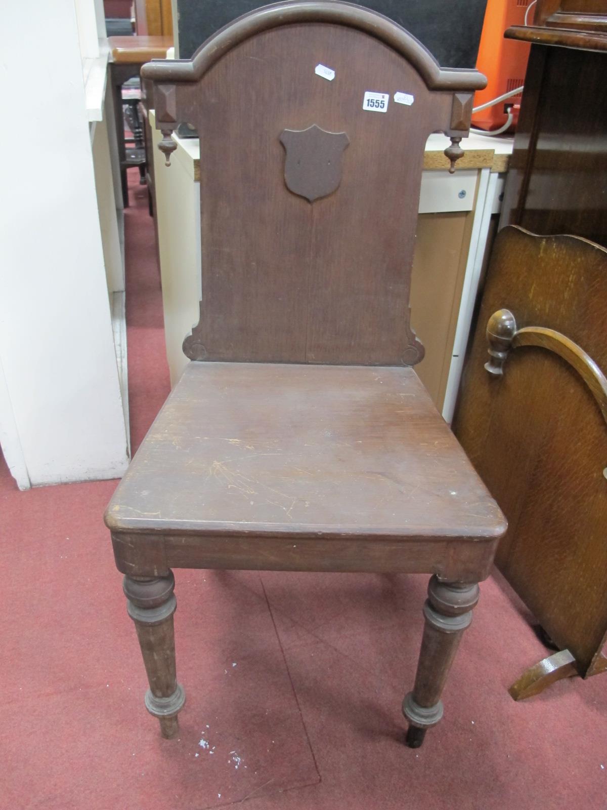 A XIX Century Oak Hall Chair, with an arched back, applied shield, solid seat on turned forefront