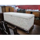 A XIX Century Mahogany Framed Ottorman, with bun feet, re-upholstered in a floral fabric 146cm wide.