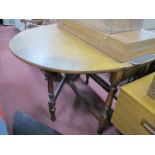 An Oak Drop Leaf Table, with an oval top on turned and block supports.