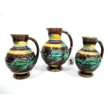 A Wedgwood Majolica Graduated Set of Three Pitcher Jugs, each of ovoid form with tapered necks,