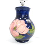 A Moorcroft Pottery Ovoid Table Lamp, painted in the pink Magnolia pattern against a dark blue