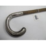 Walking Cane, circa 1900, with ribbed body and engraved silver crook handle.