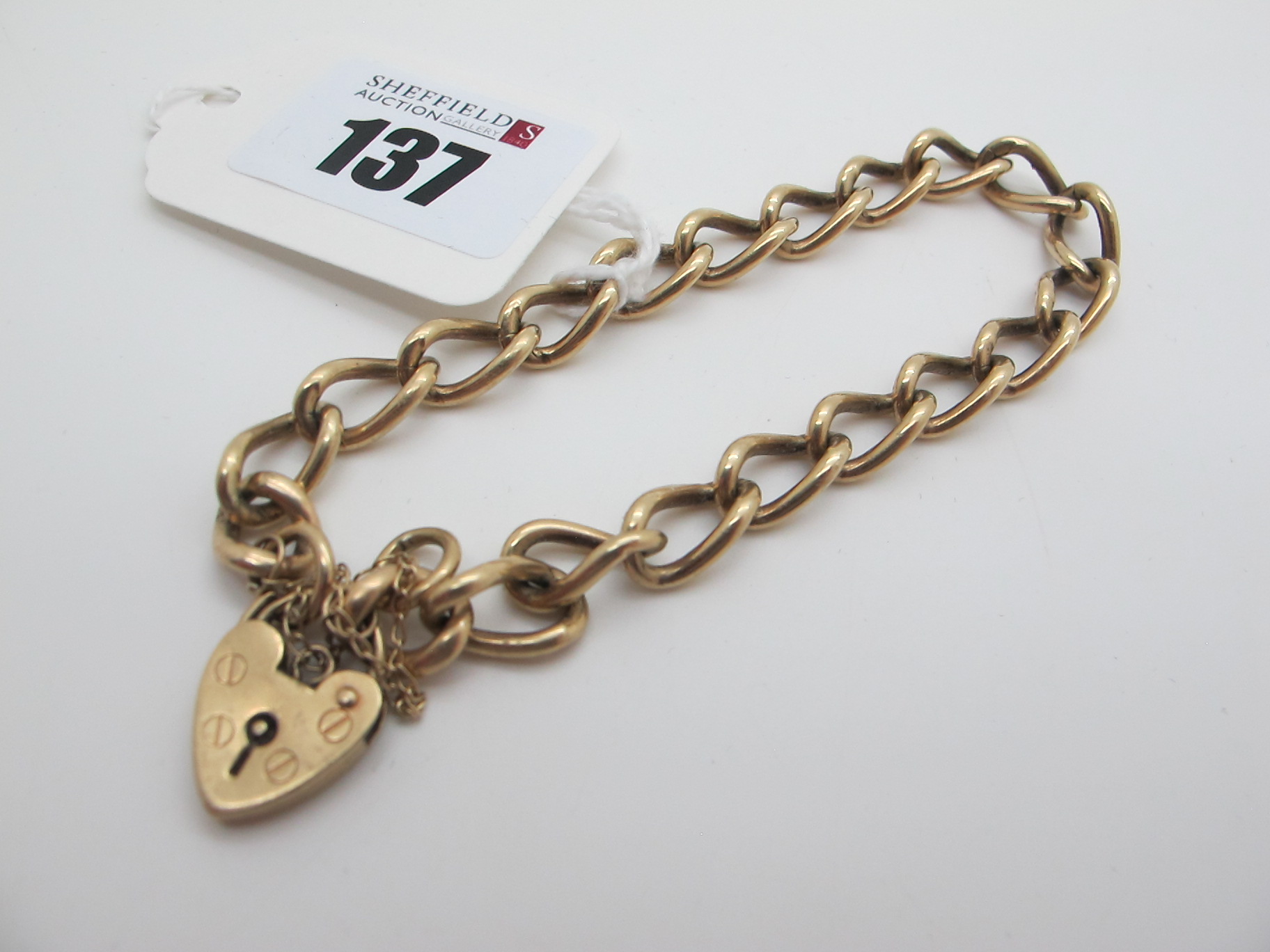 A 9ct Gold Curb Link Bracelet, to 9ct gold heart shape padlock style clasp (overall weight 20grams).