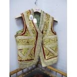 Two Turkish Waistcoats, with gilt braided decoration, one on maroon ground the other green. (2)