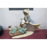 Lladro 'Playful Push'. young girl pushing a sleigh with puppies, in matt glaze, No 2234 30cm high,