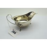A Hallmarked Silver Sauce Boat, London 1933, with wavy cut edge with loop handle, raised on three