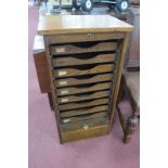 A 1920's Oak Office Floor Standing Filing Cabinet, with nine pull out trays and tambour roll