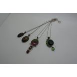 Modern Polished Hardstone and Other Inset Pendants, including "925", each on a chain. (4)