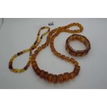 A Single Strand Graduated Square Cut Amber Bead Necklace, together with an elasticated amber