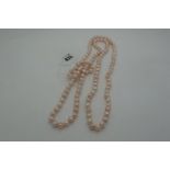 A Long Single Strand Fresh Water Pearl Bead Necklace, knotted.