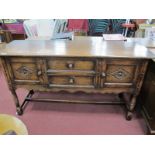 A XVII Century Style Oak Sideboard, with two central drawers flanking cupboard doors with lozenge