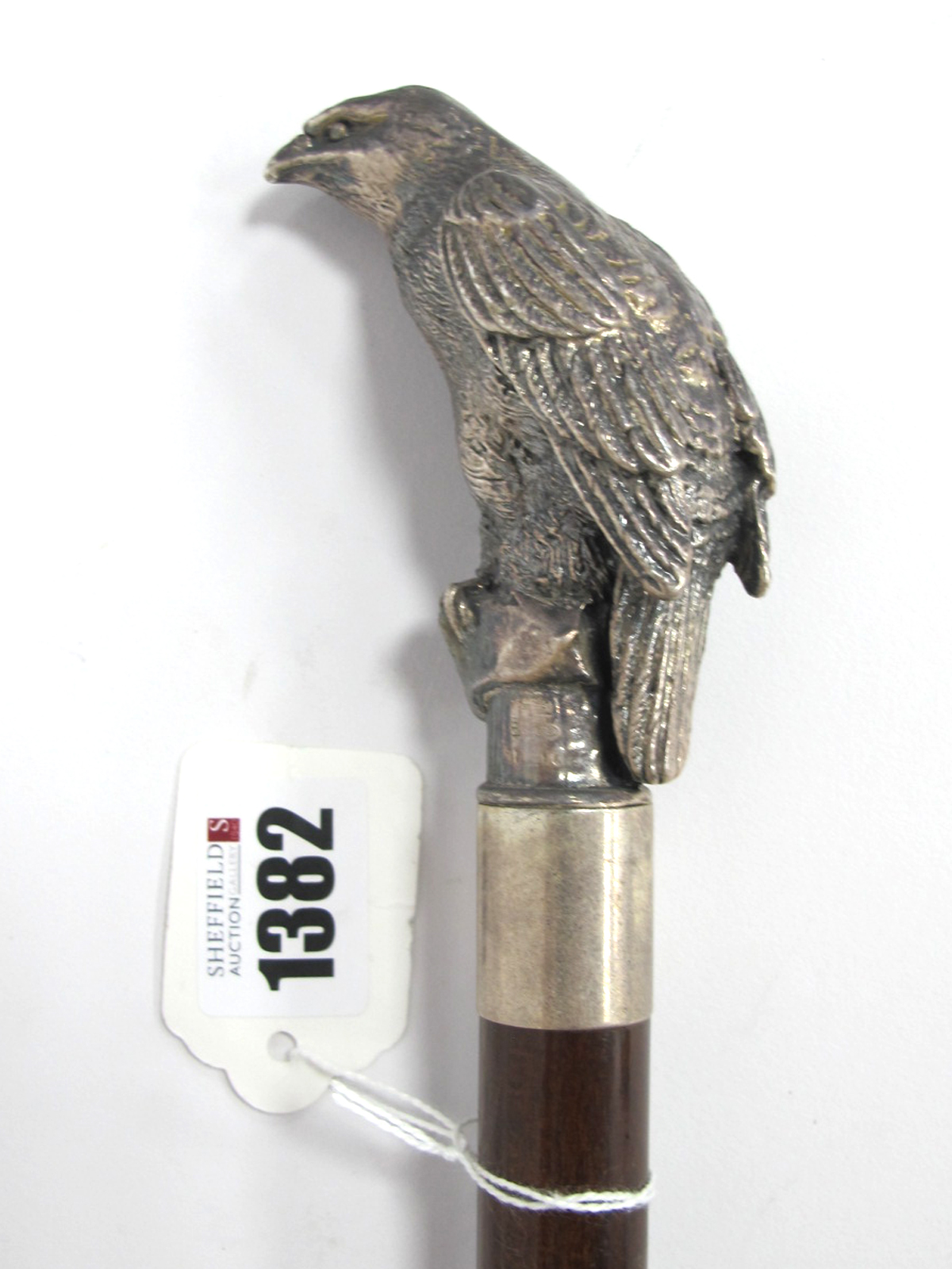 A Walking Cane with Bird of Prey Perched on Rock Handle, stamped 925, with white metal ferrule,