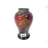 A Moorcroft Pottery Vase, of baluster form, painted in the Pomegranate pattern against a dark blue