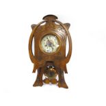 An Early XX Century Wall Clock in the Art Nouveau Style, the walnut case carved with sinuous
