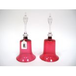 A Pair of Late Victorian Cranberry Glass Bells, with clear shaped handles, 28cm high. (2)