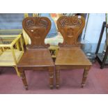 A Pair of Mid XIX Century Hall Chairs, with carved scroll backs, solid seats on turned forefront