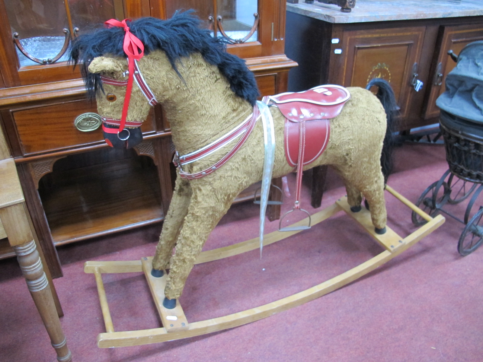 A XX Century Gold Plush Rocking Horse, with a red saddle, on rockers. 78cm high.
